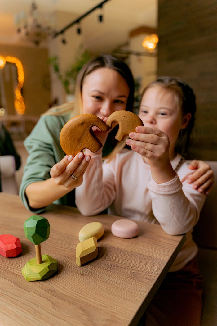 Smiling mother and daughter bonding while playing with wooden toys indoors.